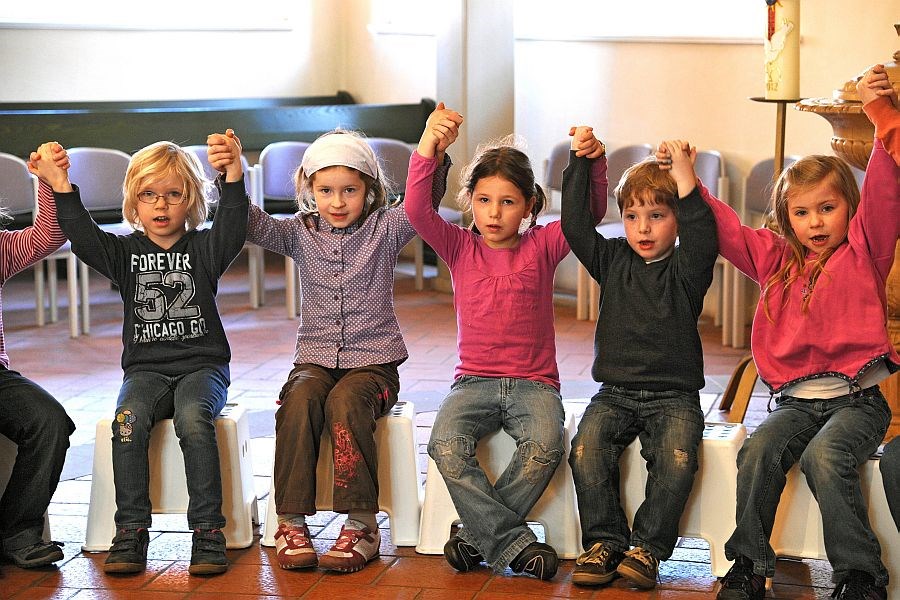 Kinder halten sich im Kindergottesdienst an den Händen