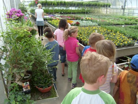 Kinder besichtigen ein Treibhaus mit Blumen