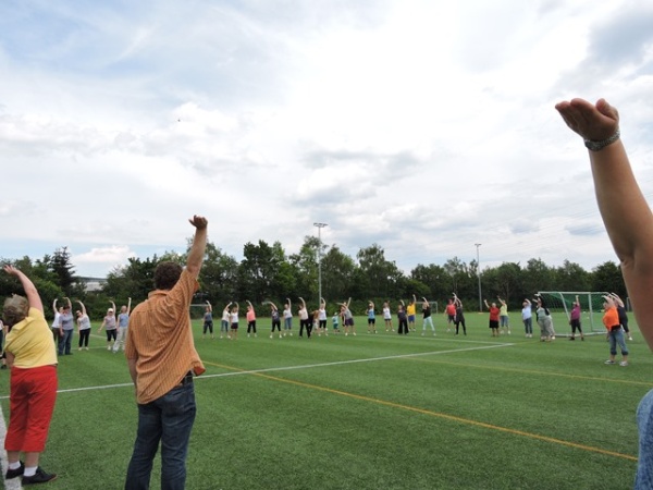 Alle machen Gymnastik auf der Wiese