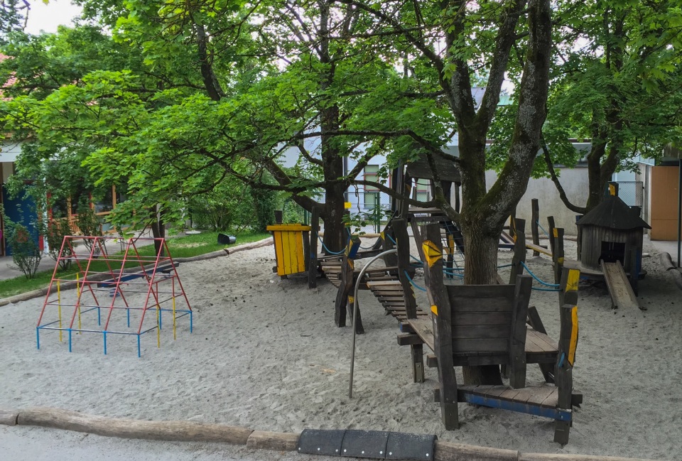 Buntes Klettergerüst und Holzhängebrücke über dem Sandkasten auf dem Spielplatz im Kindergarten St. Hildegard