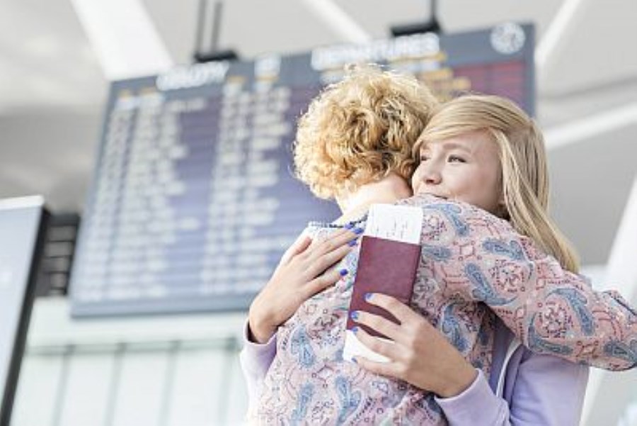 Mutter und Tochter umarmen sich am Flughafen