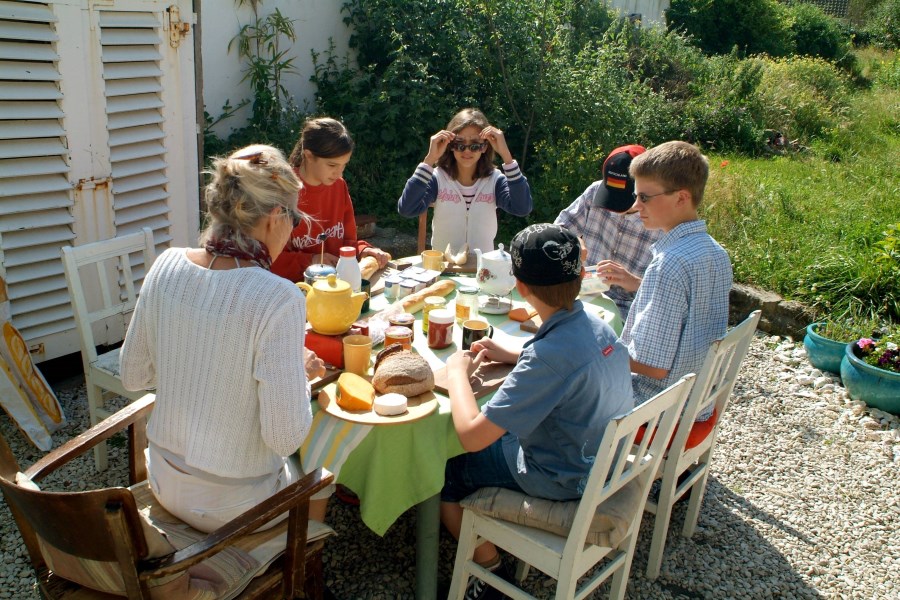 Familie am Gartentisch in der Sonne