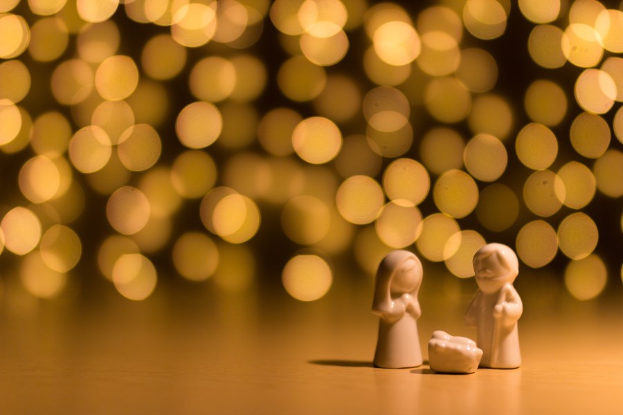 Figuren Heilige Familie vor diffusem Lichtermeer