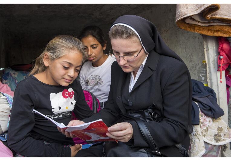 Schwester Adina freut sich, als die Kinder ihr im Schutzhaus ihre Schulhefte zeigen.