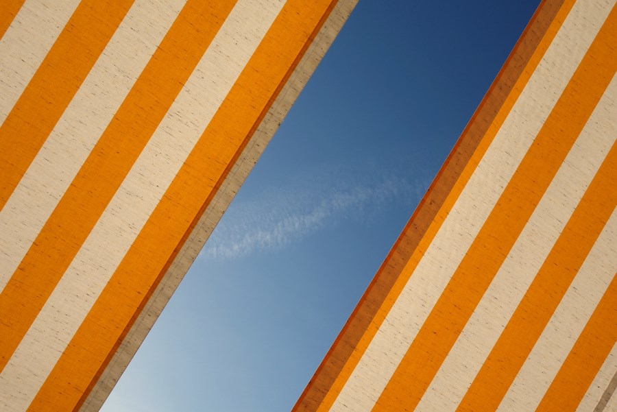 orange-weiß-gestreifte wände diagonal durch blauen himmel getrennt