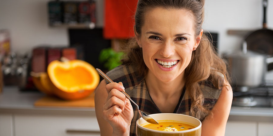 Frau in Küche mit Kürbissuppe