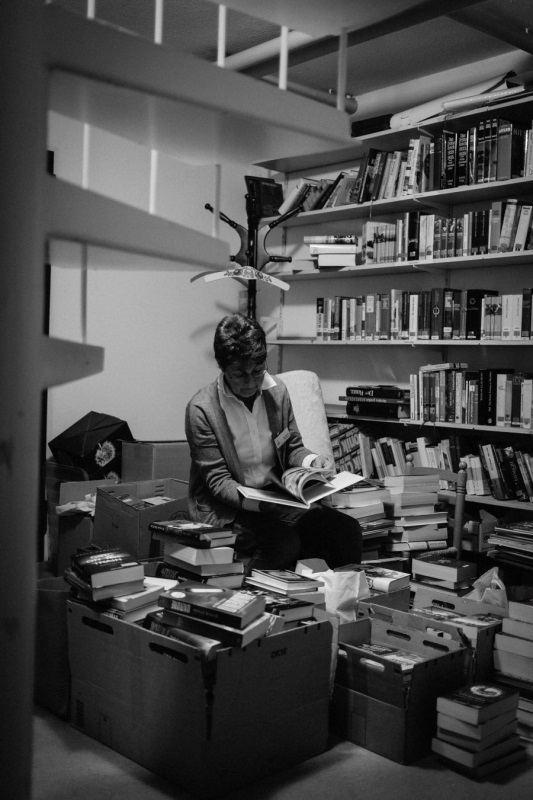 Marianne Brucker schaut durch Bücher im Büchereikeller