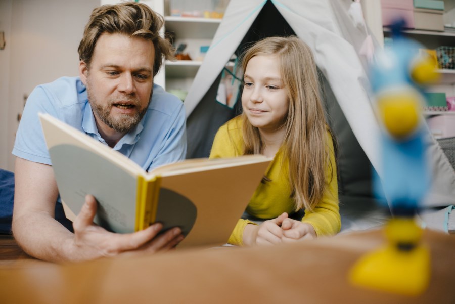 Vater liest mit Tochter ein Buch