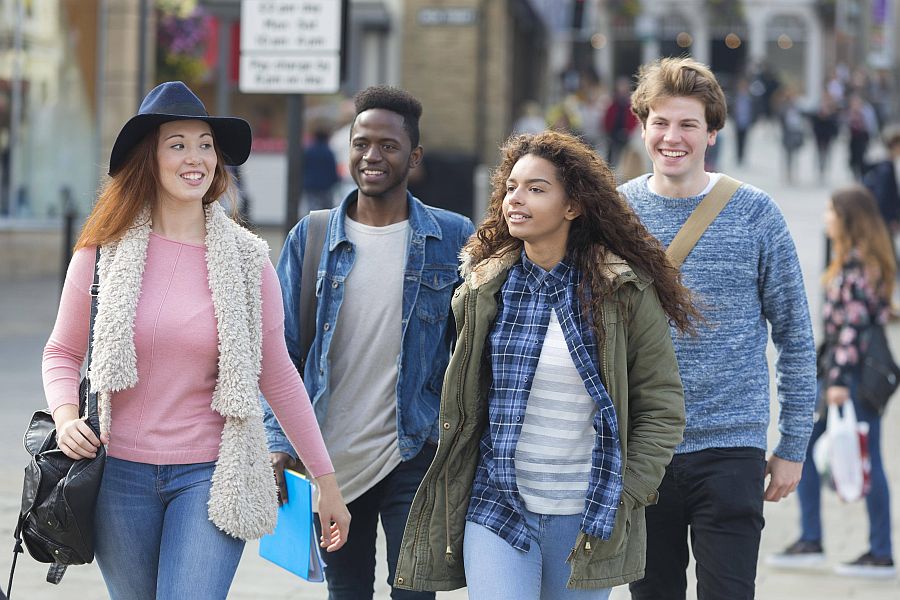 Jugendliche laufen lachend auf einer städtischen Straße