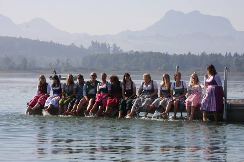 Lobpreischor Riedering sitzt auf einem Steg im Simssee