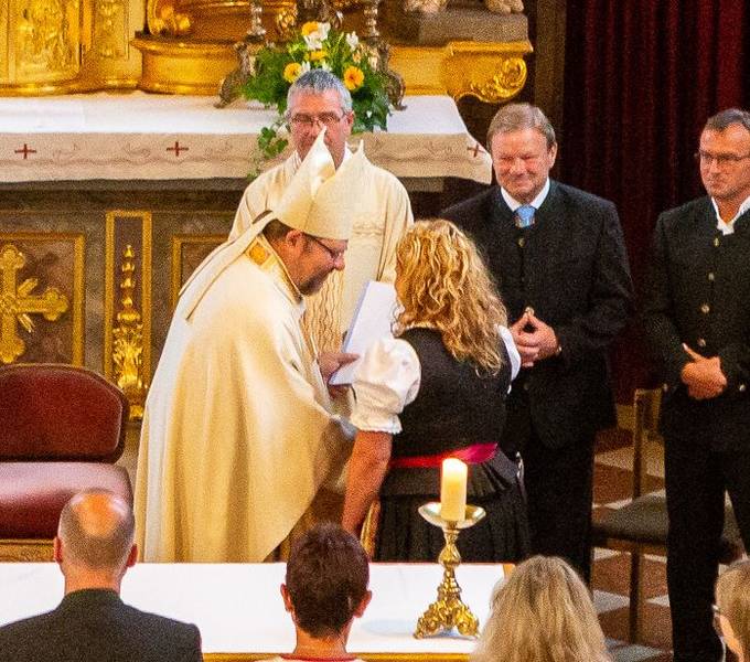 Annette Forster bekommt von Weihbischof Wolfgang Bischof die Beauftragungsurkunde überreicht.