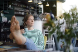 junge Frau genießt auf Terrasse Getränk