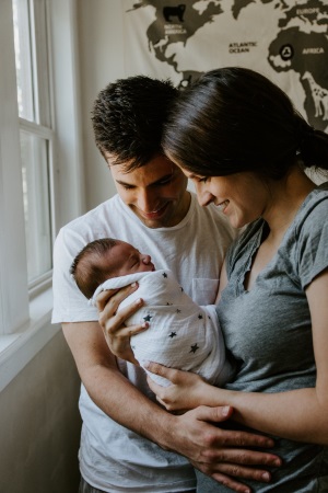 Paar hält neugeborenen Säugling in den Armen
