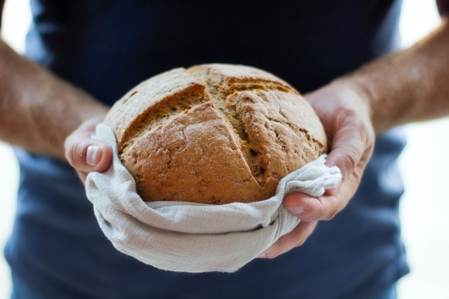 Mann hält frisch gebackenes Brot