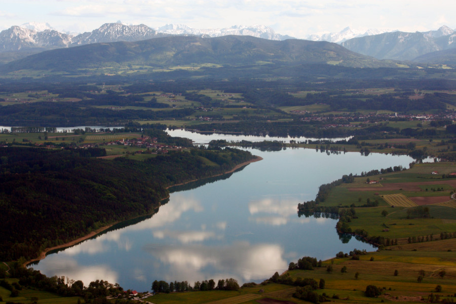 Blick auf Tachinger See mit Bergen im Hintergrund