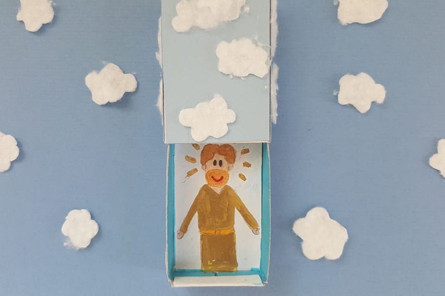 Streichholzschachtel mit Bild von Jesus auf blauem Papier mit weißen Wattewolken