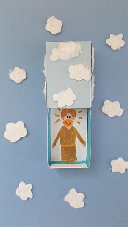 Streichholzschachtel mit Bild von Jesus auf blauem Papier mit weißen Wattewolken