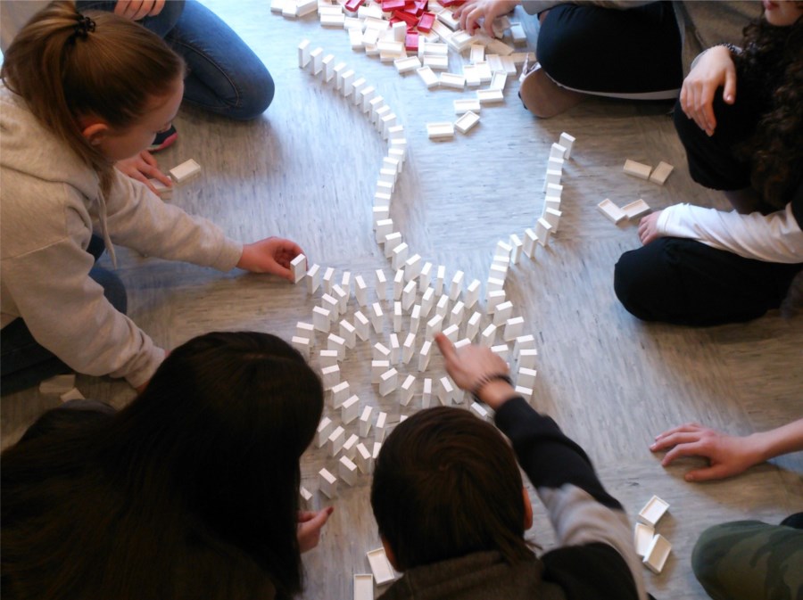 Schüler mit Dominosteinen am Boden
