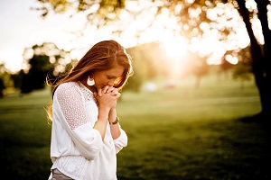junge Frau betet in der Natur