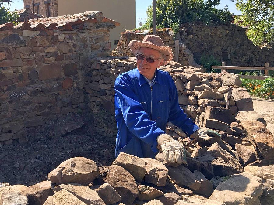 Pater Pius Mühlbacher im Garten bei Arbeiten an einer Steinmauer