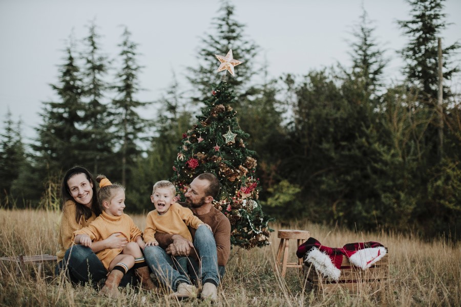 Glückliche Familie vor Weihnachtsbaum, im Freien