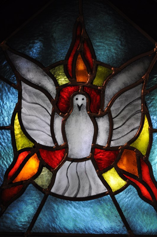 Der heilige Geist, dargestellt in einem bunten Kirchenfenster als Taube