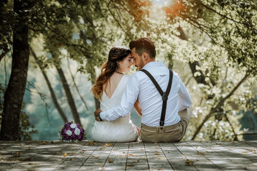 Hochzeitspaare sitzend auf einem Steg