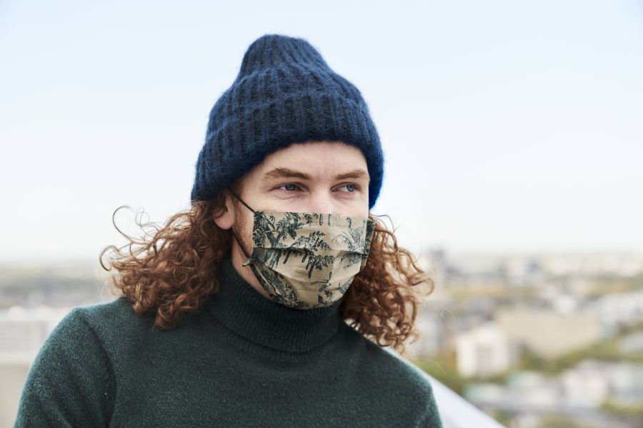 junger Mann nachdenklich mit Maske