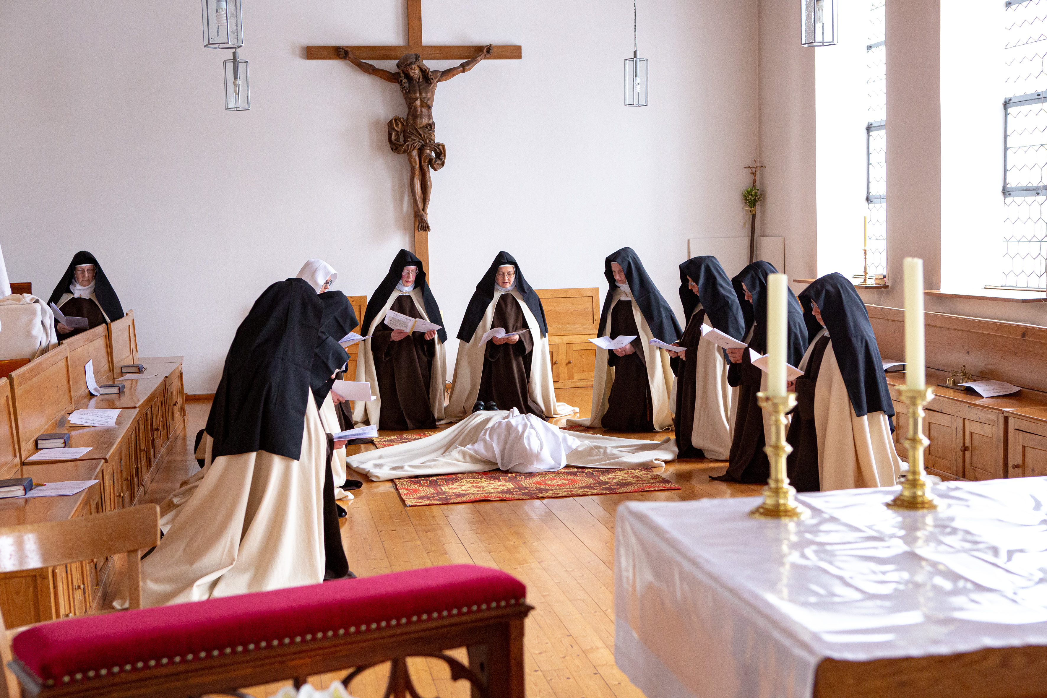 Als Zeichen ihrer Hingabe liegt Sr. Margareta im Altarraum im Kreis ihrer Mitschwestern