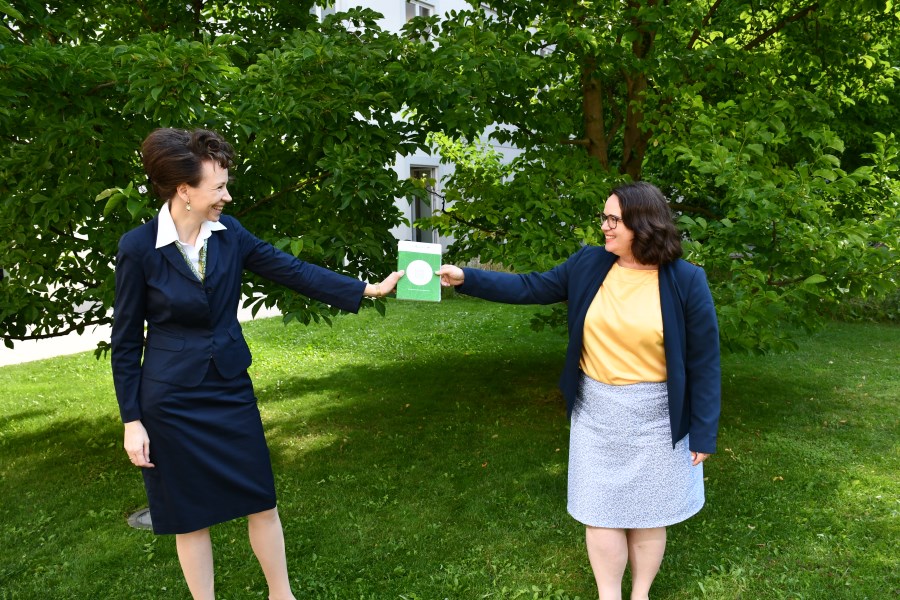 Dr. Sandra Krump übergibt Gabriele Bognitschar ein Heft