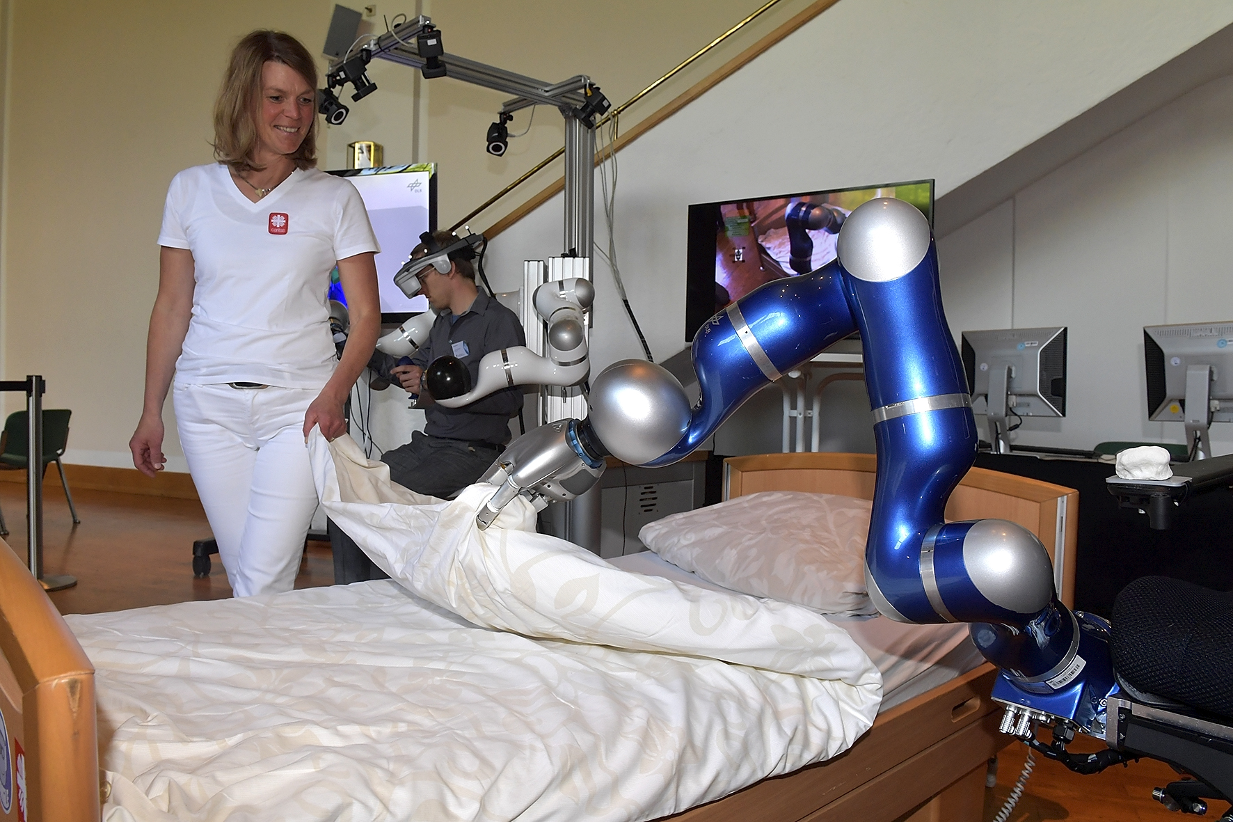 Assistenz-Roboter EDAN deckt ein Bett auf.