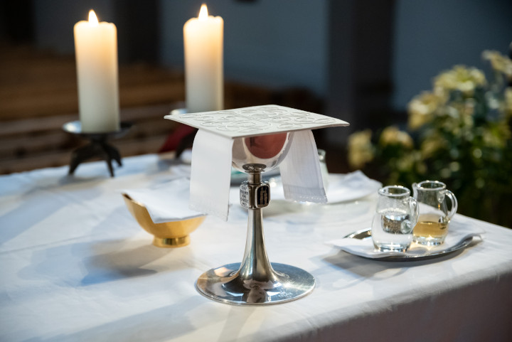Kelch, Schale, Kerzen auf Altar