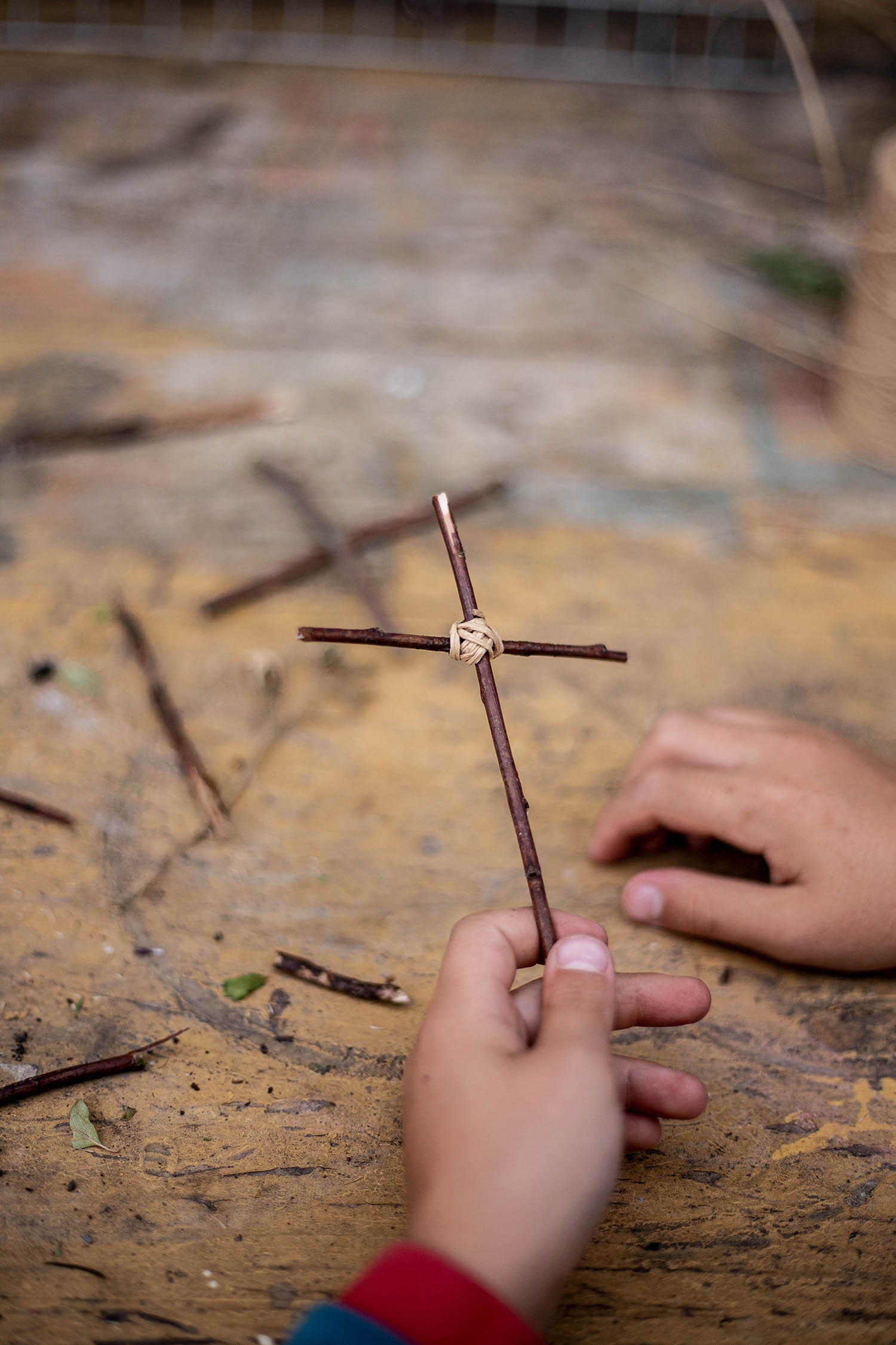 Kinderhände halten Bastelkreuz