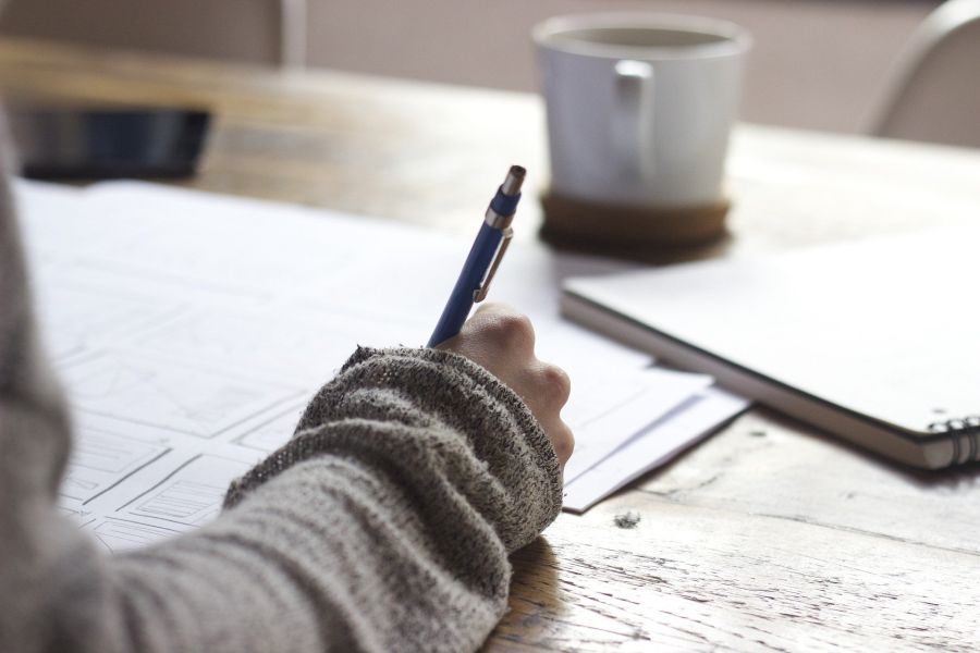 Hand mit Stift und Papier