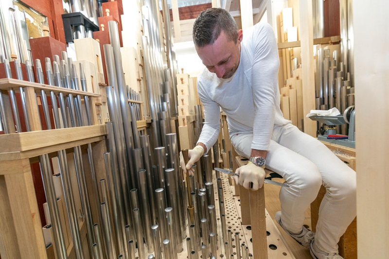 Auf dem Foto ist ein Experte zu sehen, der die Orgel einbaut.