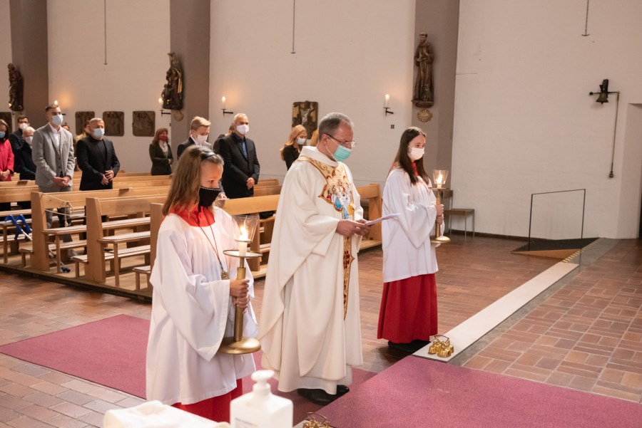 Ministrantinnen mit Priester vor Altarstufen