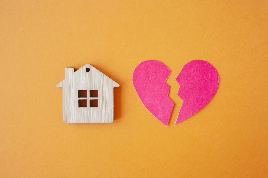 Symbole Haus und zerbrochenes Herz auf gelbem Grund
