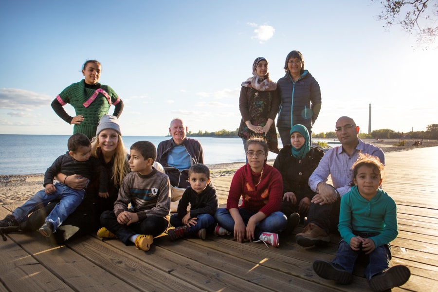 Auf dem Foto ist eine Flüchtlingsfamilie zu sehen, die in Kanada mittels des Porjekts NesT eine neue Heimat gefunden hat.