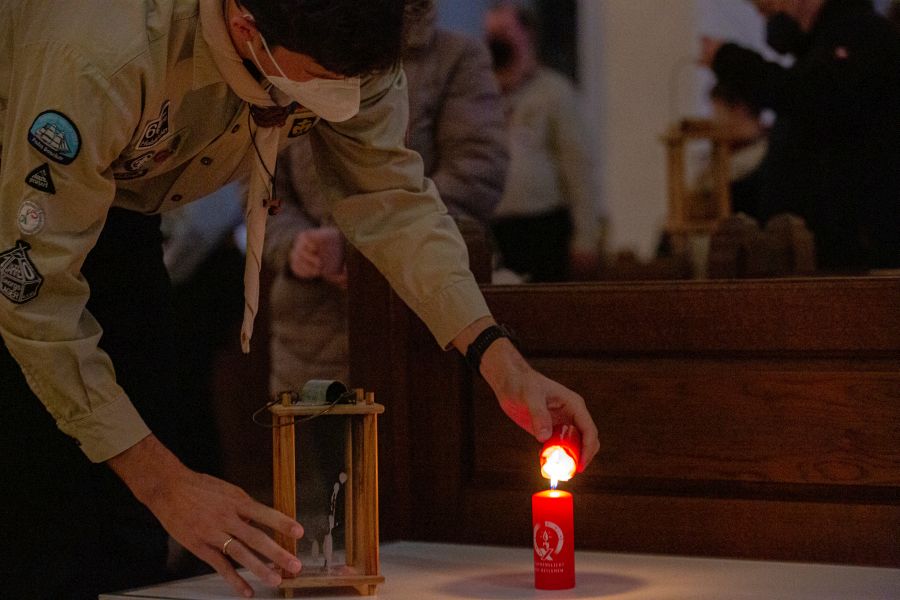 Entzündung des Friedenslichts aus Betlehem zum Weitertragen durch einen Pfadfinder in der Münchner Liebfrauenkirche