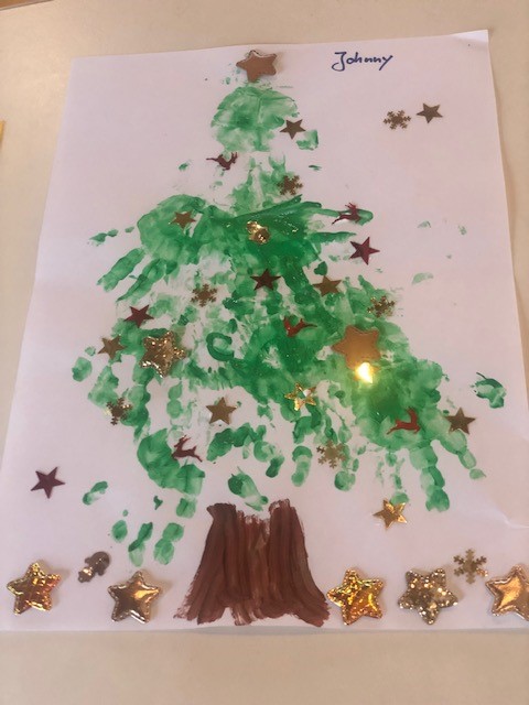 Ein Christbaum mit Handabdrücken gemalt und mit Glitzer bestreut.