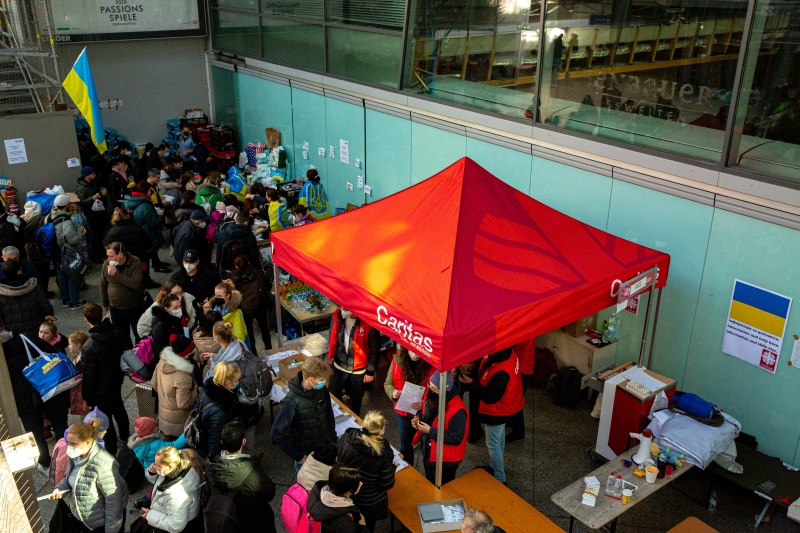 Auf dem Foto ist der Caritas-Infopoint am Münchner Hauptbahnhof zu sehen, an dem jeden Tag viele Flüchtlinge aus der Ukraine Hilfe und Unterstützung suchen.