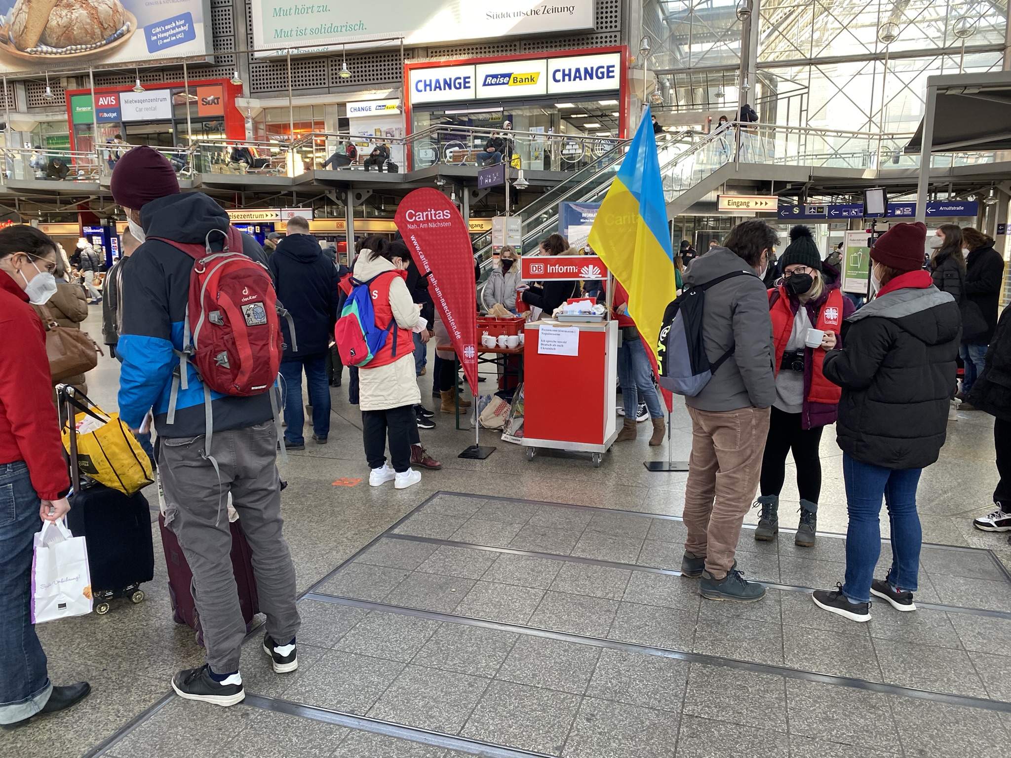 Helfer und Geflüchtete am Caritas Infopoint am Hauptbahnhof in München
