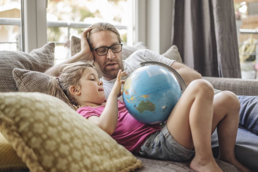 Vater und Tochter schauen auf Globus