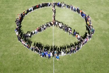 Schülerinnen und Schüler der Maria-Ward-Realschule St. Zeno in Bad Reichenhall formen ein Friedenssymbol