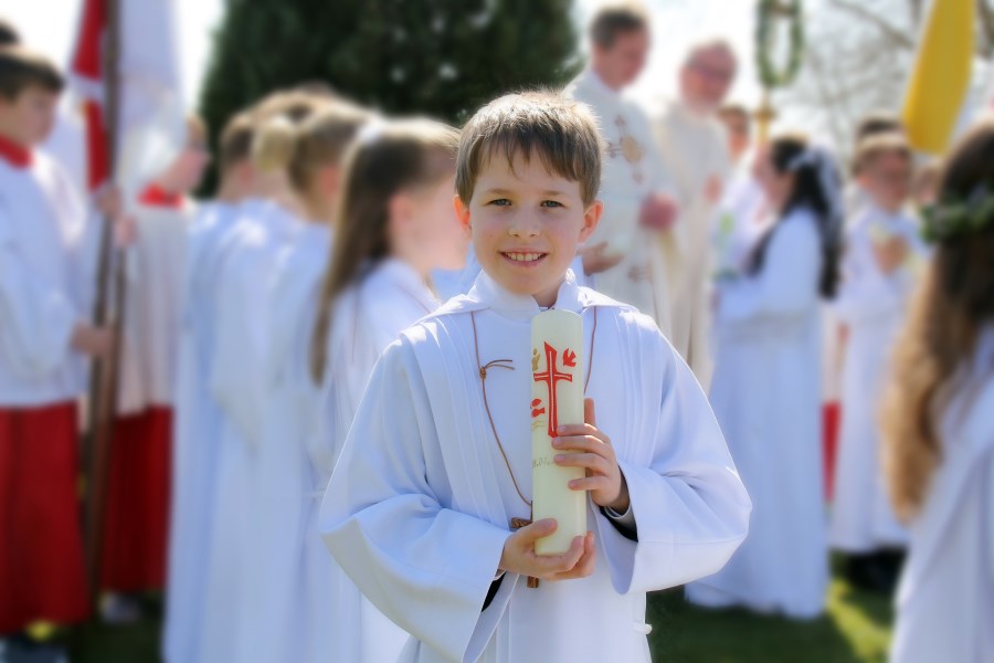 Auf dem Foto ist ein Junge bei der Erstkommunion zu sehen.