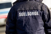 Person mit dunkelblauer Jacke mit der Aufschrift "Seelsorge"