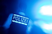 Polizist mit Schutzweste im Dunkeln bei Blaulicht