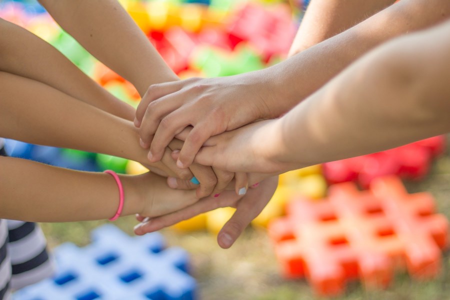 Hände von Kindern halten einander