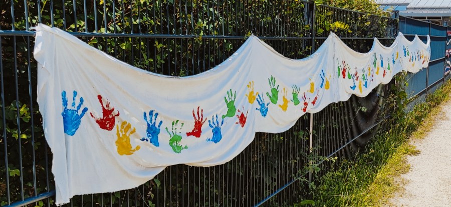 Hände der Kindergartenkinder auf einem Banner