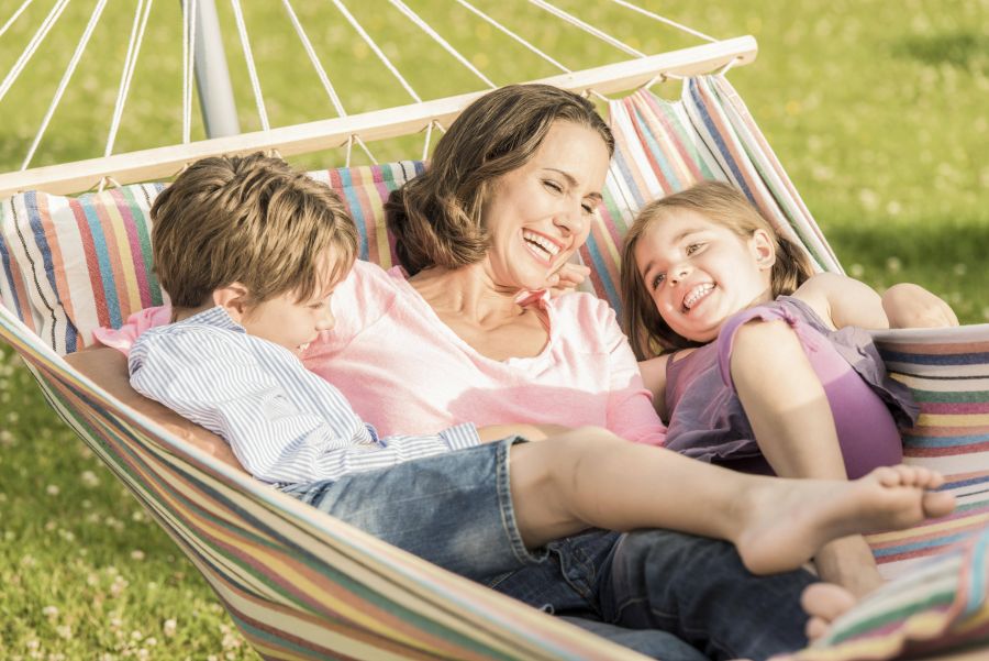 Mutter lachend mit zwei Kindern in der Hängematte